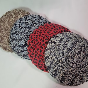 May include: Four round woven coasters in different patterns. The coasters are brown, blue and white, red and black, and black and white.