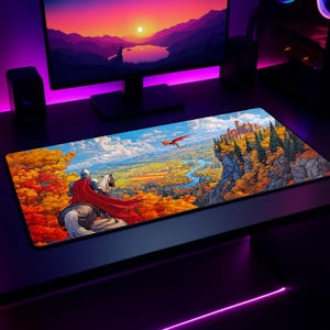 May include: A rectangular mousepad featuring a fantasy landscape with a knight on horseback, a red dragon, and a castle on a cliff. The scene is set in a valley with autumn foliage. The mousepad is on a black desk with a computer monitor.