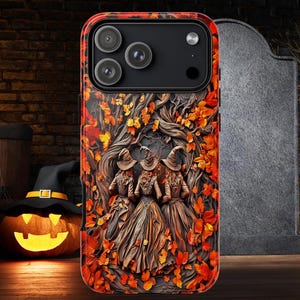 May include: A Halloween-themed phone case featuring a detailed illustration of three witches in a forest setting, surrounded by autumn leaves. The case has a textured, three-dimensional appearance with a pumpkin and witch's hat in the background.