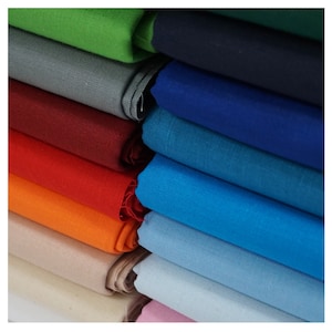 May include: A stack of fabric swatches in various colours, including green, grey, red, orange, blue, and pink.