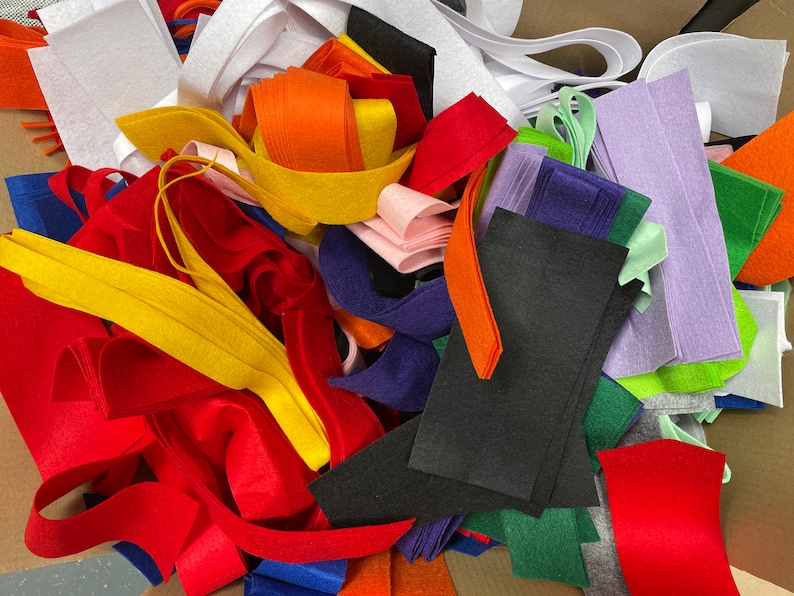 K&ouml;nnte beinhalten: Eine Vielzahl von Filzstoffresten in verschiedenen Farben, darunter Rot, Orange, Gelb, Gr&uuml;n, Blau, Lila und Wei&szlig;. Der Filz ist zu einem Stapel angeordnet, wobei sich einige St&uuml;cke &uuml;berlappen.