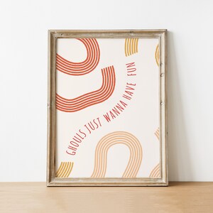 May include: A framed print with a white background and red and yellow abstract shapes. The text "Ghouls just wanna have fun" is written in red.