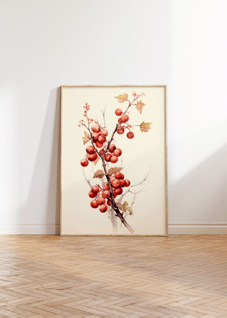 May include: A watercolor painting of a branch with red berries and leaves. The painting is framed in a light wood frame and is hanging on a white wall.