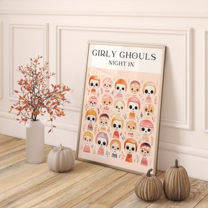 May include: A framed print with a pink background and the text "Girly Ghouls Night In". The print features a pattern of colorful, cartoon-style sugar skulls with floral accents.