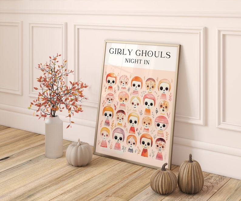 May include: A framed print with a pink background and the text "Girly Ghouls Night In". The print features a pattern of colorful, cartoon-style sugar skulls with floral accents.