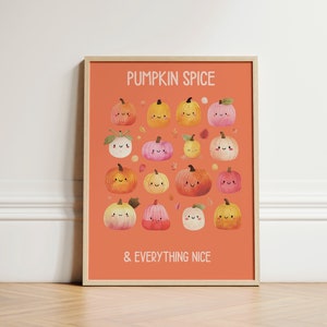 May include: A framed art print with an orange background featuring the text "PUMPKIN SPICE & EVERYTHING NICE." The print showcases a collection of smiling, cartoon pumpkins in various colors, including orange, yellow, and pink, with autumn leaves scattered around.
