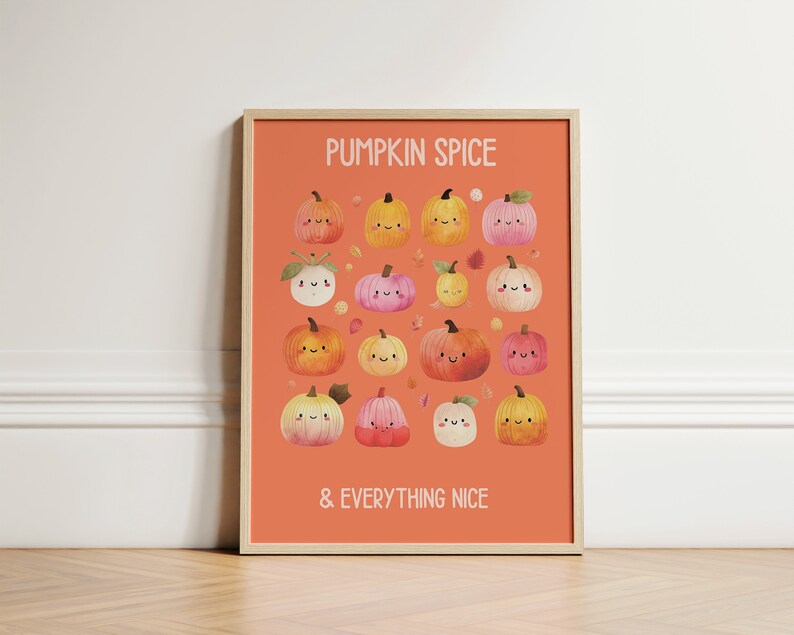 May include: A framed art print with an orange background featuring the text "PUMPKIN SPICE & EVERYTHING NICE." The print showcases a collection of smiling, cartoon pumpkins in various colors, including orange, yellow, and pink, with autumn leaves scattered around.