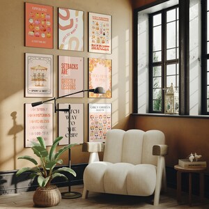 May include: A living room corner with a white armchair and a floor lamp. The wall is decorated with nine colorful posters with Halloween-themed illustrations and text. The posters include phrases like "Spooky & Sweet", "Girly Ghouls", "Boo Their In Pink", and "Setbacks Are Ghostly Lessons".