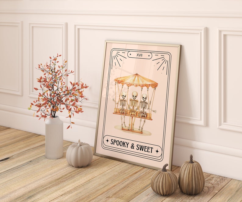 May include: A pink and white illustrated print with three skeletons riding a carousel. The print has a black frame and the text "Spooky & Sweet" at the bottom.