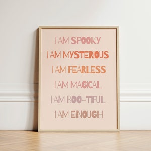 May include: A framed print with a pink background and white text that reads "I am spooky, I am mysterious, I am fearless, I am magical, I am boo-tiful, I am enough".