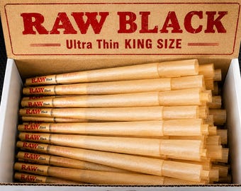 May include: A cardboard box containing a stack of light brown, pre-rolled paper cones. The box lid features the red text RAW BLACK and Ultra Thin KING SIZE. Each individual cone is marked with the red RAW Black logo near the filter tip.