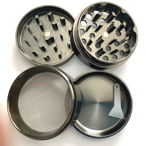 May include: A four-piece black metal grinder with a screen, a scraper, and a top with a circular pattern of holes.