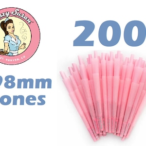 May include: 200 pink 98mm pre-rolled cones with the Blazy Susan logo. The cones are in a fan shape and the logo is a cartoon of a woman in a pink dress and a white apron.