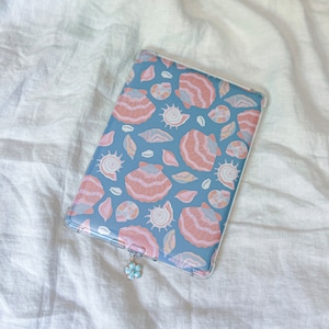 May include: A blue and pink seashell patterned tablet case with a clear plastic cover and a small flower charm.