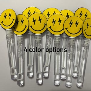 May include: A set of 10 yellow smiley face bubble wands with black lightning bolts and a black outline. The wands are clear plastic with a white wand inside. The text "4 color options" is printed on the image.