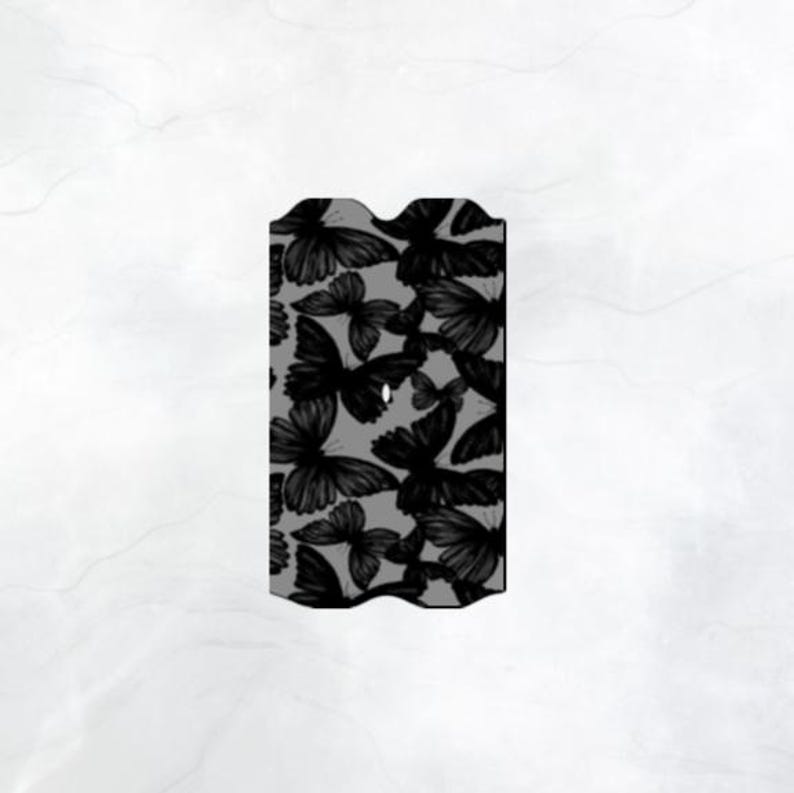 Puede incluir: Una funda de tel&eacute;fono gris y negra con un patr&oacute;n de mariposas negras.