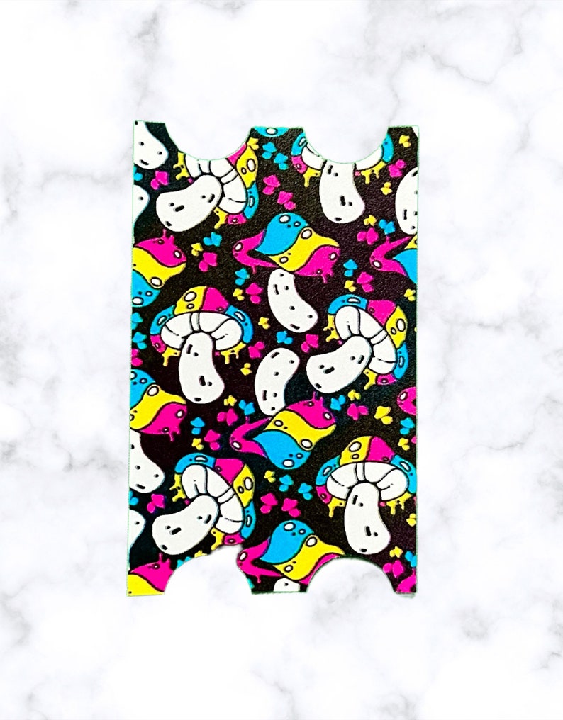 Puede incluir: Una pegatina con un patr&oacute;n repetitivo de setas coloridas sobre un fondo negro. Las setas son blancas con detalles en rosa, azul y amarillo.