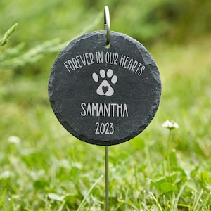 May include: Black slate garden stone memorial with the text "Forever in our hearts" and a paw print with a heart in the center. The name Samantha and the year 2023 are also engraved on the stone.
