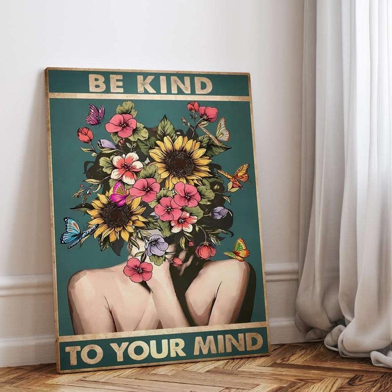 May include: A teal poster with gold lettering that reads "BE KIND TO YOUR MIND." The artwork features a woman with a floral headpiece of sunflowers and pink flowers, with butterflies. The background is teal.