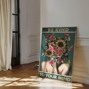 May include: A framed poster with the text "BE KIND TO YOUR MIND." The artwork depicts a woman's torso and head, with a floral arrangement replacing the head. The flowers are a mix of pink, yellow, and orange, with butterflies scattered throughout.