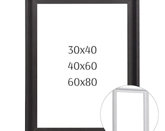 Könnte beinhalten: Ein schwarzer Bilderrahmen mit rechteckiger Öffnung. Der Rahmen hat eine dunkle, strukturierte Oberfläche. Text auf dem Rahmen zeigt verfügbare Größen: 76x102 cm, 102x152 cm und 152x203 cm. Ein kleinerer, weißer Rahmen ist in einem Kreis abgebildet.