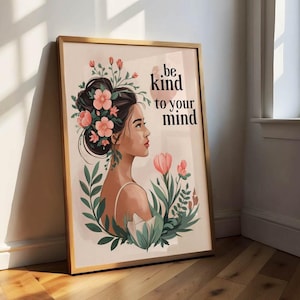 May include: A framed art print depicting a woman's profile adorned with flowers and greenery. The artwork uses a gentle colour scheme and includes the text "be kind to your mind". The frame is light brown.