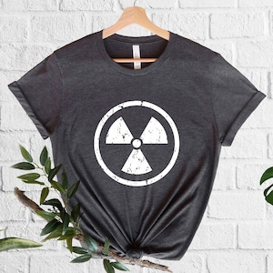 May include: A dark gray t-shirt with a white distressed radiation symbol graphic.