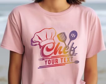 May include: Pink t-shirt featuring a colourful graphic design of a chef's hat, cooking utensils, and the text "Chef Your Text".