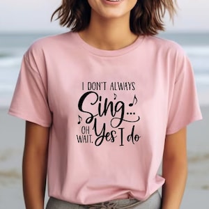 May include: A pink t-shirt with the text "I don't always sing... oh wait, yes I do" in black lettering.