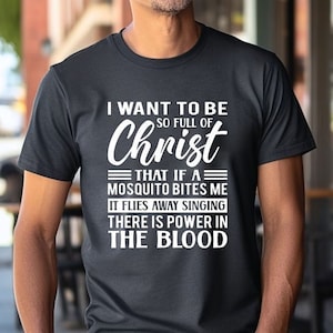 May include: A black t-shirt with white text that reads "I want to be so full of Christ that if a mosquito bites me it flies away singing there is power in the blood."