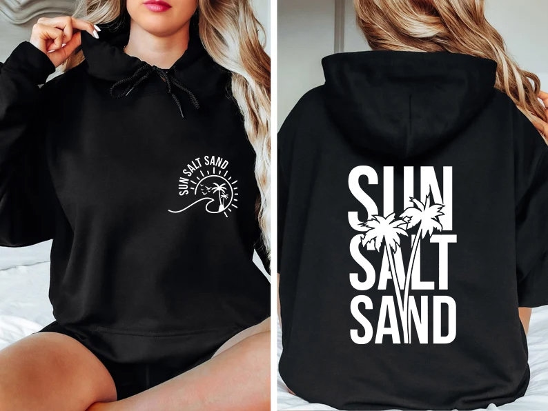 May include: Black hoodie with a white graphic that says "SUN SALT SAND" with palm trees and a wave. The graphic is on the front of the hoodie. The back of the hoodie has the same graphic but the words are stacked vertically.