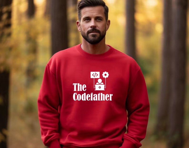May include: Red sweatshirt with white text that reads "The Codefather" and a graphic of a person sitting at a computer with code and a gear.