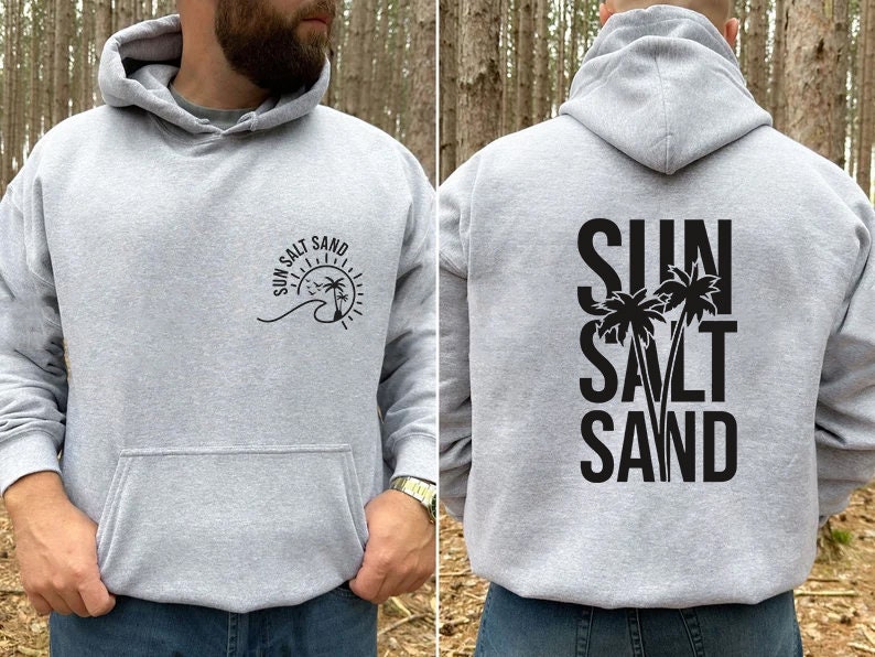 May include: A gray hooded sweatshirt with a black graphic on the front that says "Sun Salt Sand" with a palm tree and wave design. The back of the sweatshirt has a black graphic that says "Sun Salt Sand" with two palm trees.