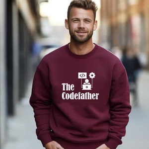 May include: A maroon sweatshirt with a white graphic design that says "The Codefather" with a computer, code, and gear icon.
