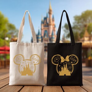 Puede incluir: Dos bolsas de mano con tem&aacute;tica de Disney. Una es beige, la otra negra. Ambas tienen una silueta dorada de las orejas de Mickey Mouse, un castillo, fuegos artificiales y el a&ntilde;o 2020. Las bolsas tienen asas largas y est&aacute;n sobre una superficie de madera.