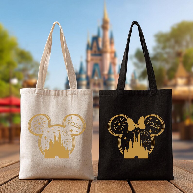 Puede incluir: Dos bolsas de mano con tem&aacute;tica de Disney. Una es beige, la otra negra. Ambas tienen una silueta dorada de las orejas de Mickey Mouse, un castillo, fuegos artificiales y el a&ntilde;o 2020. Las bolsas tienen asas largas y est&aacute;n sobre una superficie de madera.