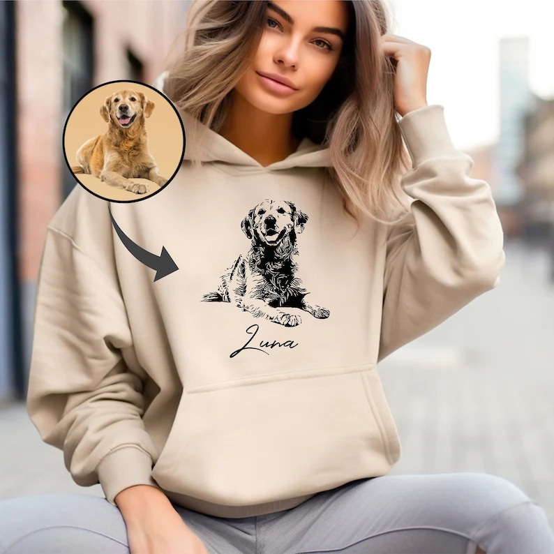 May include: A beige hoodie with a black and white illustration of a dog and the name "Luna" printed on the front.