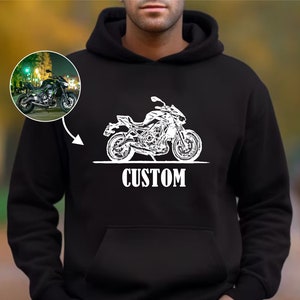 May include: Black hooded sweatshirt with a white silhouette of a motorcycle and the word "CUSTOM" printed on the front.