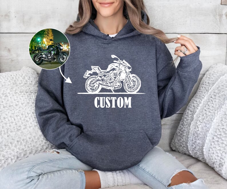May include: A dark gray hoodie with a white outline of a motorcycle and the word "CUSTOM" printed on the front.