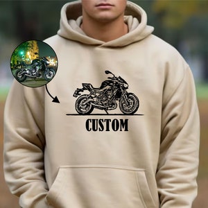 May include: A beige hoodie with a black motorcycle graphic and the word "CUSTOM" printed on the front.