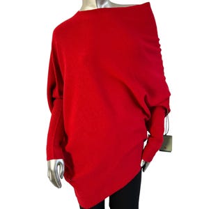 Könnte beinhalten: Ein roter Oversize-Pullover mit einem drapierten Ausschnitt und langen Ärmeln.