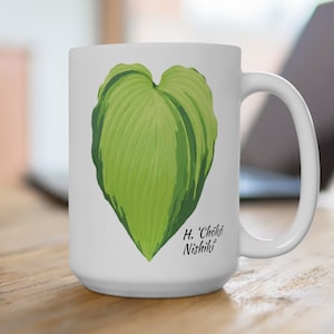 May include: White ceramic mug with a green heart-shaped leaf design and the text "H. 'Choko Nishiki'" printed on the front.