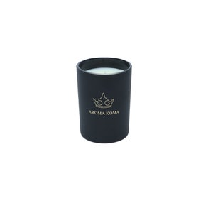 May include: Black candle in a black glass jar with a gold crown and the text "Aroma Koma" on the front.