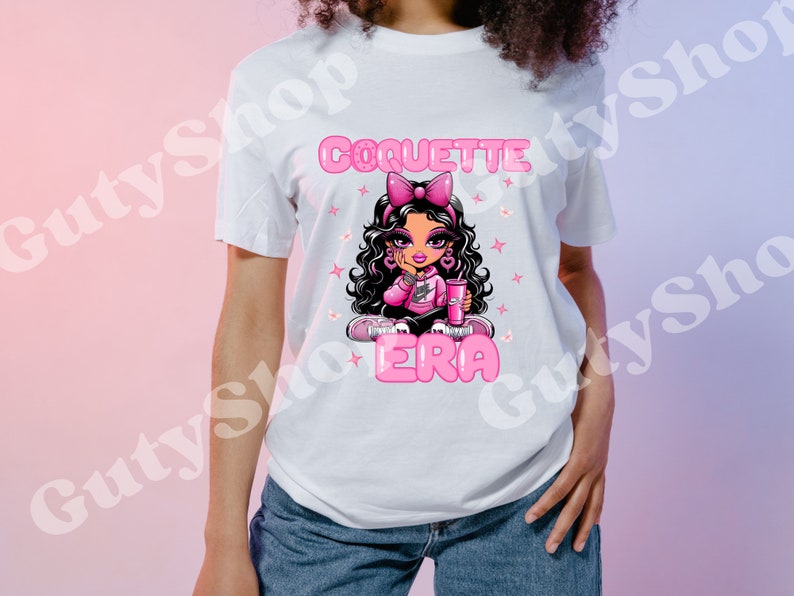 May include: White t-shirt featuring a pink cartoon girl wearing a pink shirt and holding a pink drink. The text "Coquette Era" is printed in pink letters below the girl.