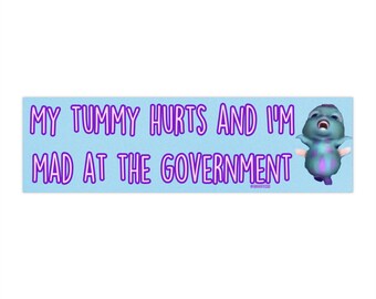 Puede incluir: Una pegatina azul con el texto "My tummy hurts and I'm mad at the government" en texto morado. Un personaje de dibujos animados azul con acentos morados se muestra en el lado derecho de la pegatina.