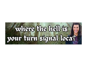 May include: A bumper sticker with a forest background and the text "where the hell is your turn signal loca?" with a photo of a man with long brown hair.
