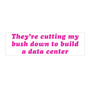 May include: A rectangular bumper sticker with a white background and the text "They're cutting my bush down to build a data center" printed in a bold, bright pink sans-serif font centered across three lines on the sticker surface.