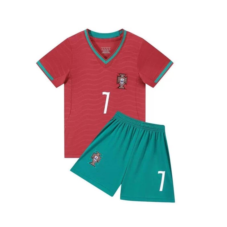 May include: A red and teal soccer uniform set. The short-sleeved jersey has a V-neck and the number 7 in white. The shorts are teal with the number 7 in white. Both pieces feature the Portuguese coat of arms.