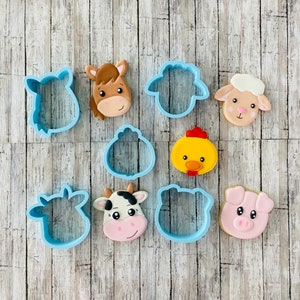 May include: A set of nine blue plastic cookie cutters shaped like farm animals. The cutters include a cow, pig, chicken, horse, sheep, and three different styles of sheep.