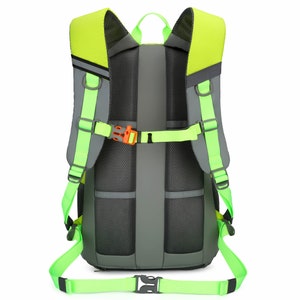 K&ouml;nnte beinhalten: Ein gr&uuml;ner und grauer Rucksack mit verstellbaren Tr&auml;gern und einem Mesh-R&uuml;ckenpanel. Der Rucksack hat ein Rei&szlig;verschlussfach und eine kleine Tasche auf der Vorderseite.
